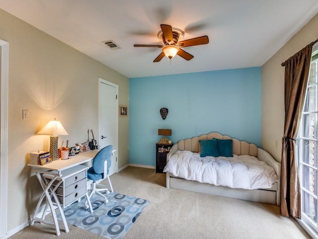 carpeted bedroom with visible vents, baseboards, and ceiling fan