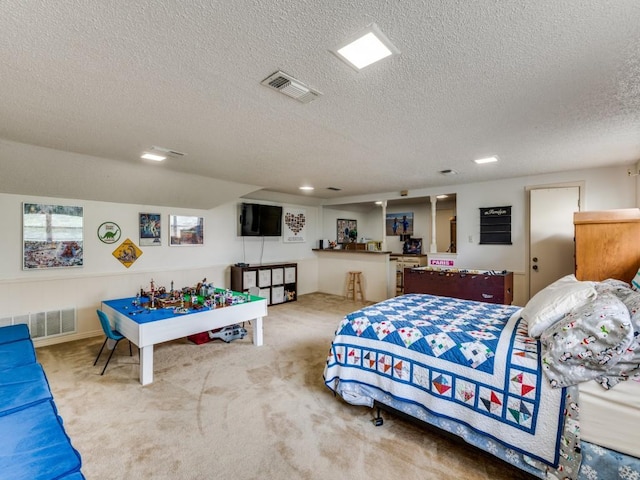 carpeted bedroom with bar area, a textured ceiling, and visible vents