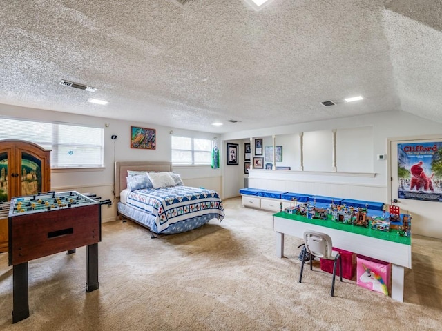 game room featuring carpet flooring, a textured ceiling, and visible vents