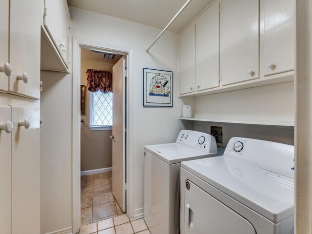 laundry room featuring cabinet space, baseboards, light tile patterned flooring, and separate washer and dryer