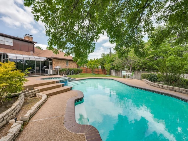 view of pool with a fenced backyard, a patio, and a pool with connected hot tub
