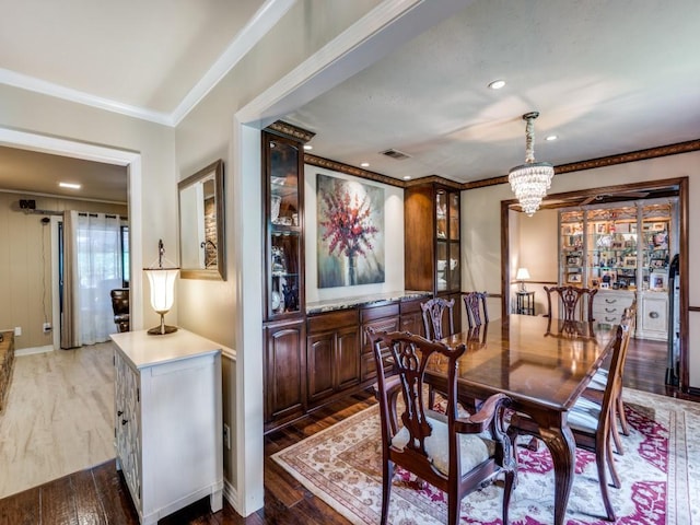 dining room featuring recessed lighting, wood finished floors, visible vents, ornamental molding, and a chandelier