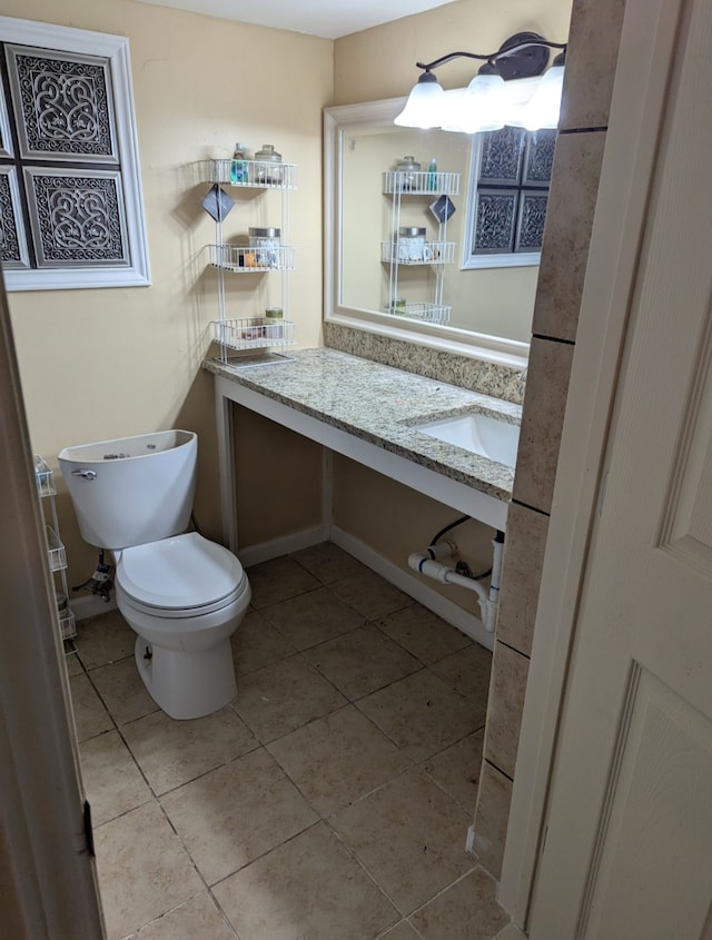 half bathroom with tile patterned floors, vanity, and toilet