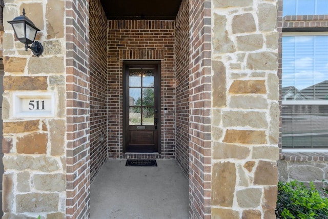 doorway to property with brick siding