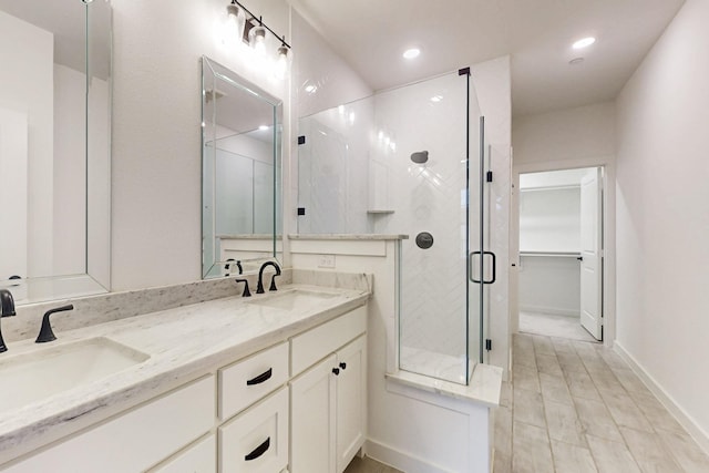 full bath with a shower stall, a sink, double vanity, and recessed lighting