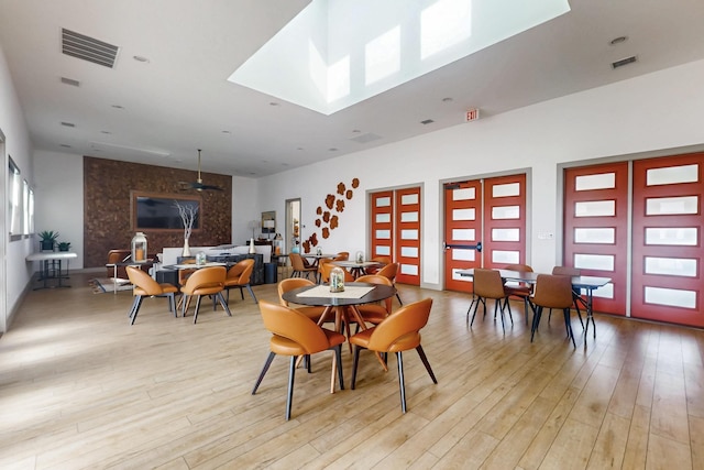 dining area featuring light wood-style flooring and visible vents