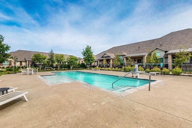 community pool with fence and a patio