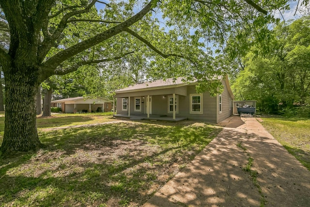 2126 Cedar St, Paris, TX 75460 - back of house with a porch, a yard, and concrete driveway