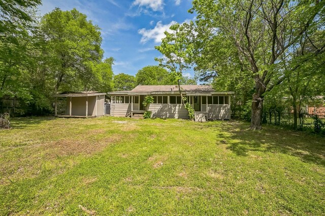 2126 Cedar St, Paris, TX 75460 - rear view of house featuring entry steps, a lawn, fence, and a sunroom
