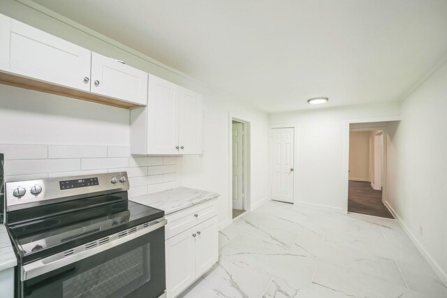 2126 Cedar St, Paris, TX 75460 - kitchen featuring electric range, marble finish floor, decorative backsplash, and white cabinets