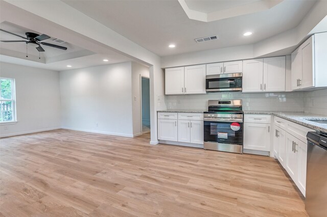 604 N E St, Arlington, TX 76011 - kitchen featuring a ceiling fan, stainless steel appliances, a raised ceiling, backsplash, and baseboards
