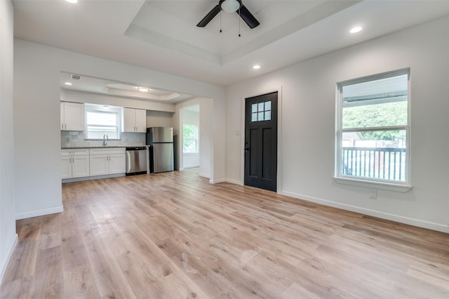 604 N E St, Arlington, TX 76011 - entrance foyer with ceiling fan, light wood-style flooring, baseboards, and a raised ceiling