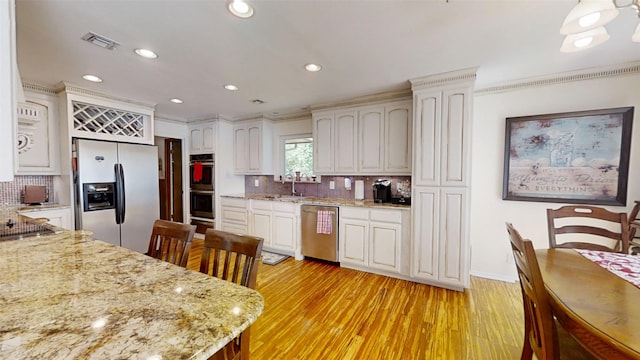 1351 Porter Ct, Granbury, TX 76048 - kitchen featuring light stone counters, decorative backsplash, light wood-style floors, stainless steel appliances, and visible vents
