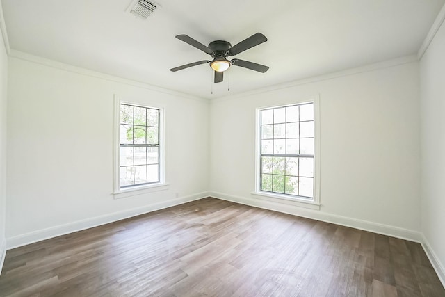 unfurnished room with dark wood finished floors, baseboards, visible vents, ceiling fan, and ornamental molding