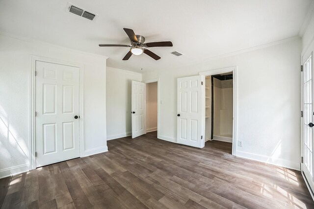 unfurnished bedroom with baseboards, visible vents, crown molding, and dark wood-style floors