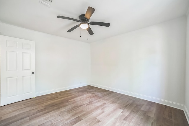empty room featuring baseboards, wood finished floors, visible vents, and ceiling fan