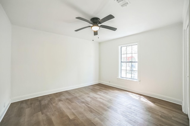 unfurnished room featuring baseboards, a ceiling fan, wood finished floors, and visible vents