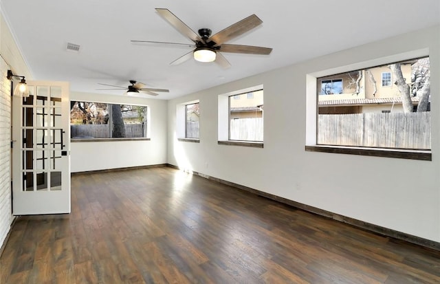 unfurnished room featuring baseboards, a ceiling fan, wood finished floors, and visible vents