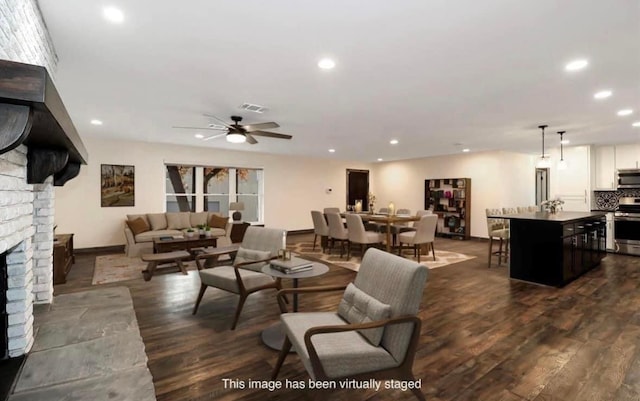 living room with dark wood finished floors, a ceiling fan, and recessed lighting
