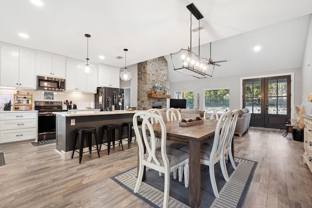 dining space featuring recessed lighting, light wood-style floors, and high vaulted ceiling