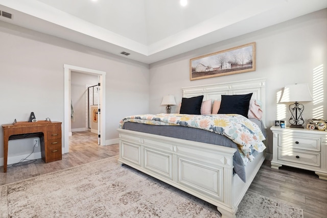 bedroom with baseboards, light wood-style floors, and visible vents