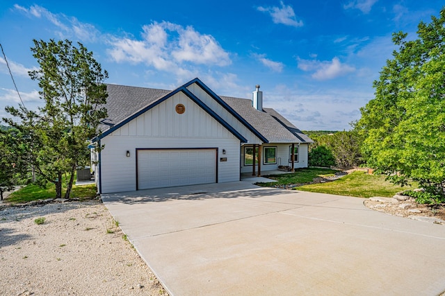 modern farmhouse with driveway, an attached garage, a shingled roof, board and batten siding, and a front yard