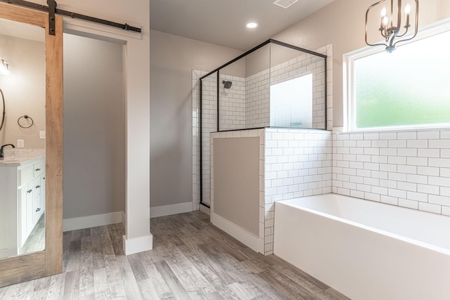 full bath with a bath, a stall shower, visible vents, wood finished floors, and vanity