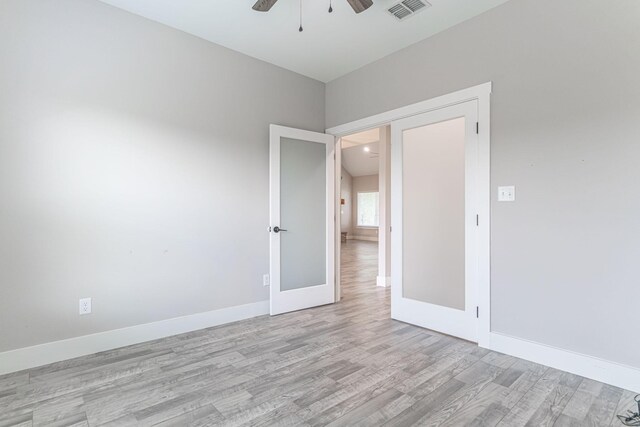 unfurnished room with ceiling fan, french doors, light wood-style flooring, baseboards, and visible vents