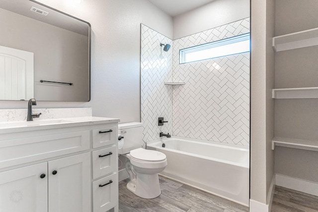 bathroom featuring wood finished floors, vanity, washtub / shower combination, and toilet