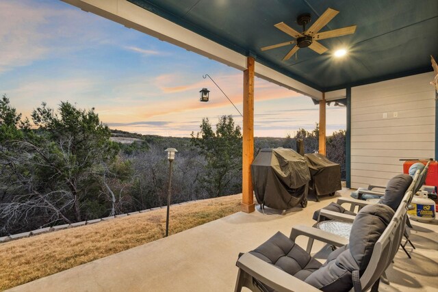 patio terrace at dusk with a grill, outdoor lounge area, and ceiling fan