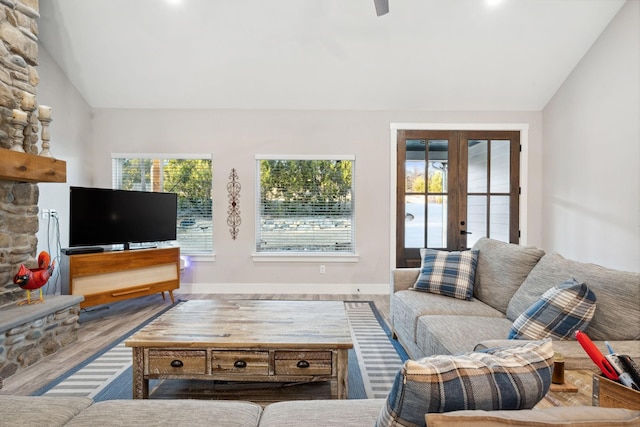 living room with lofted ceiling, a healthy amount of sunlight, french doors, and wood finished floors
