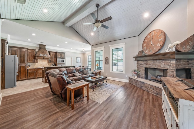 living area with lofted ceiling with beams, light wood-type flooring, recessed lighting, ceiling fan, and a fireplace