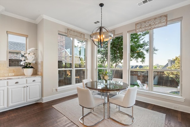 dining room featuring a chandelier, ornamental molding, dark wood-style flooring, and baseboards