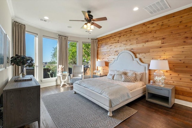 bedroom featuring ornamental molding, wood finished floors, wooden walls, recessed lighting, and a ceiling fan