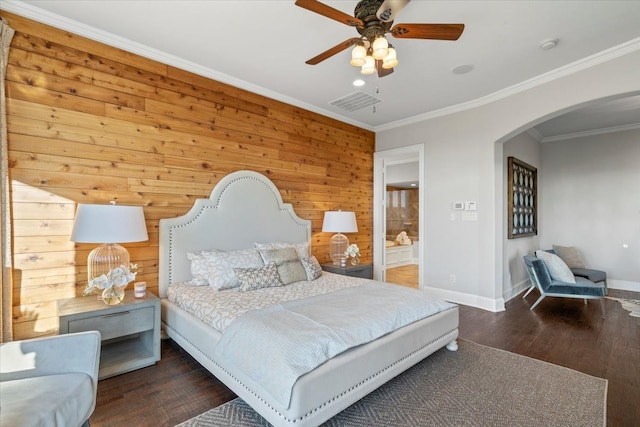 bedroom with arched walkways, baseboards, wood finished floors, ornamental molding, and wood walls