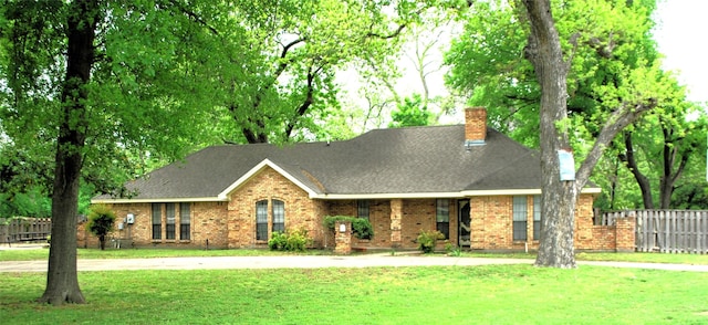 view of front of home with fence, brick siding, and a front yard