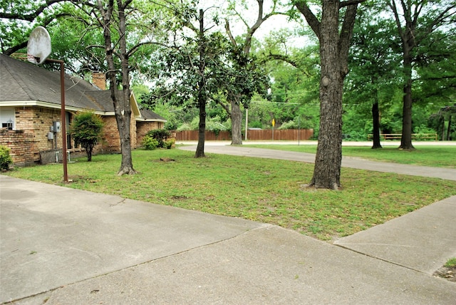 view of yard featuring driveway and fence