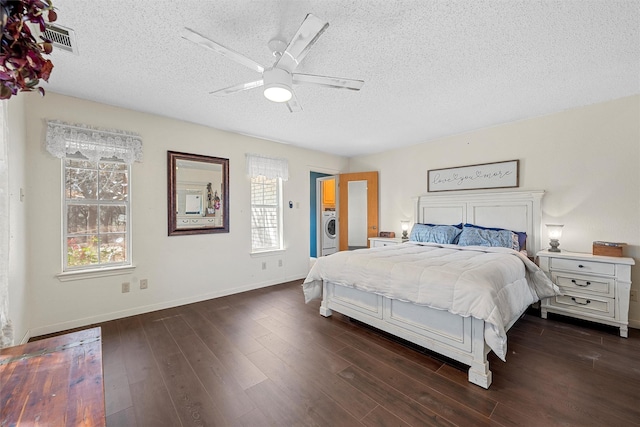 bedroom with washer / dryer, multiple windows, a textured ceiling, and dark wood-style flooring
