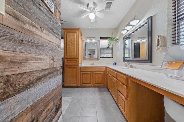bathroom with tile patterned flooring, visible vents, a sink, a textured ceiling, and ceiling fan