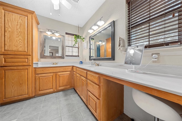 bathroom featuring tile patterned flooring, double vanity, a sink, a textured ceiling, and ceiling fan