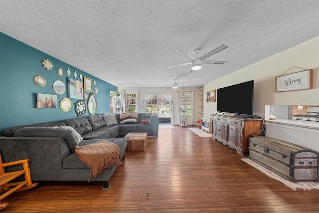 living area with wood finished floors, a textured ceiling, and ceiling fan