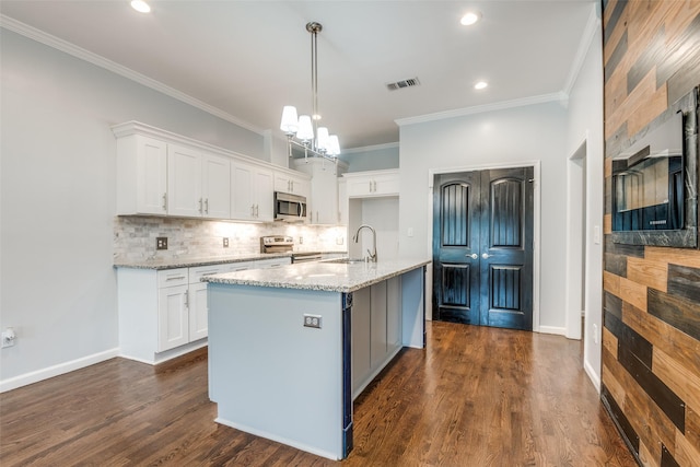 kitchen featuring backsplash, appliances with stainless steel finishes, visible vents, and white cabinets