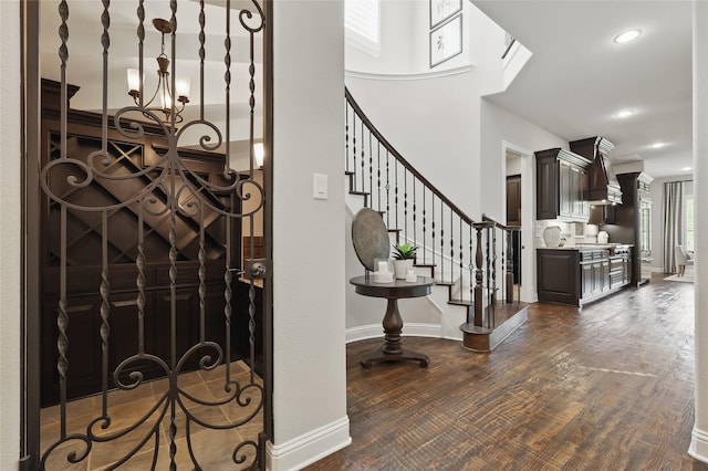 entryway with stairway, baseboards, a notable chandelier, dark wood-type flooring, and recessed lighting