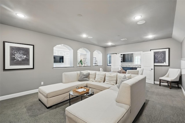living area featuring baseboards, dark carpet, and recessed lighting