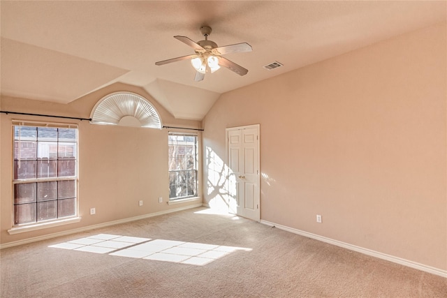 carpeted spare room with baseboards, visible vents, a wealth of natural light, and ceiling fan
