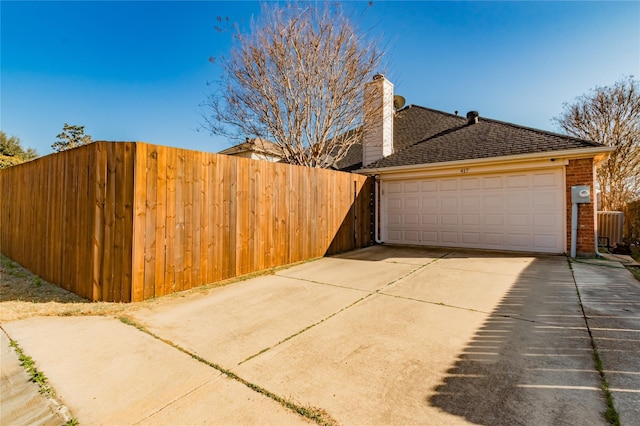 view of side of property featuring fence, a shingled roof, a chimney, and brick siding
