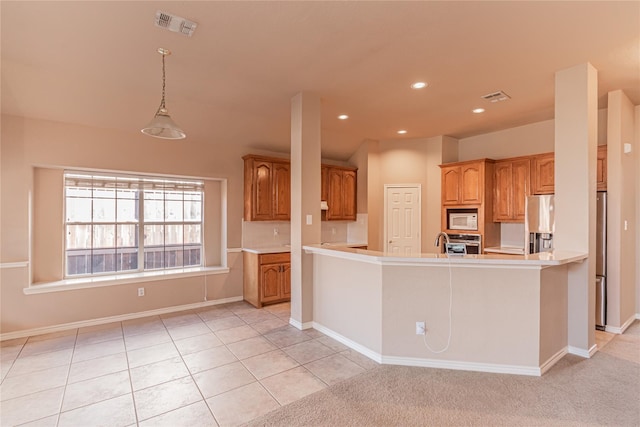 kitchen with brown cabinets, appliances with stainless steel finishes, visible vents, and light countertops