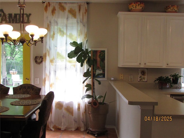 2709 Lakeside Dr, Burleson, TX 76028 - interior space with light countertops, white cabinets, a notable chandelier, and light tile patterned floors