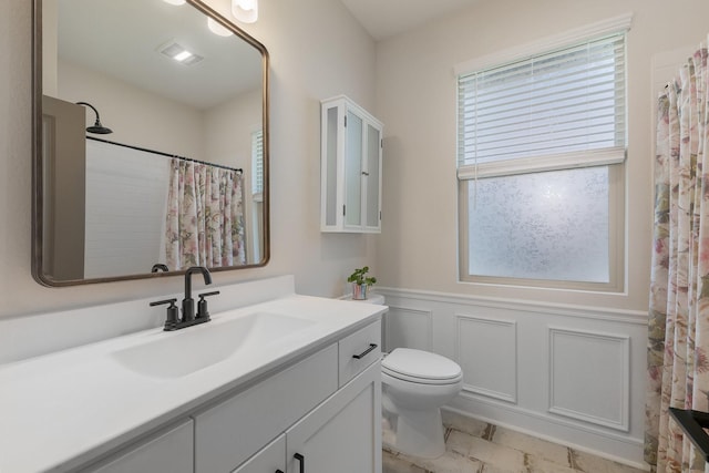1236 Monterra Way, Fate, TX 75087 - bathroom featuring wainscoting, toilet, vanity, curtained shower, and a decorative wall