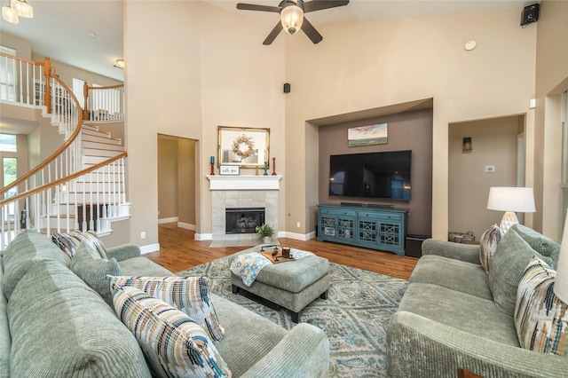 7612 Trevino Dr, Plano, TX 75025 - living room with a towering ceiling, ceiling fan, stairs, wood finished floors, and baseboards